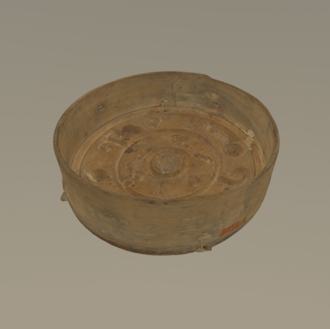 Pyöreä, puusta valmistettu juustomuotti, jonka pohjalla koristekaiverruksia.