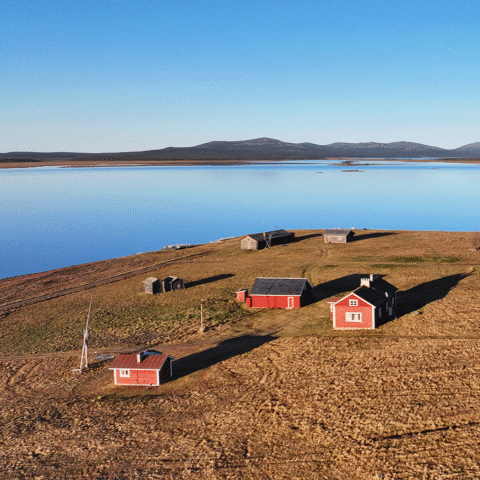 ilmakuva mutenian rakennuksista, taustalla järvi ja tuntureita
